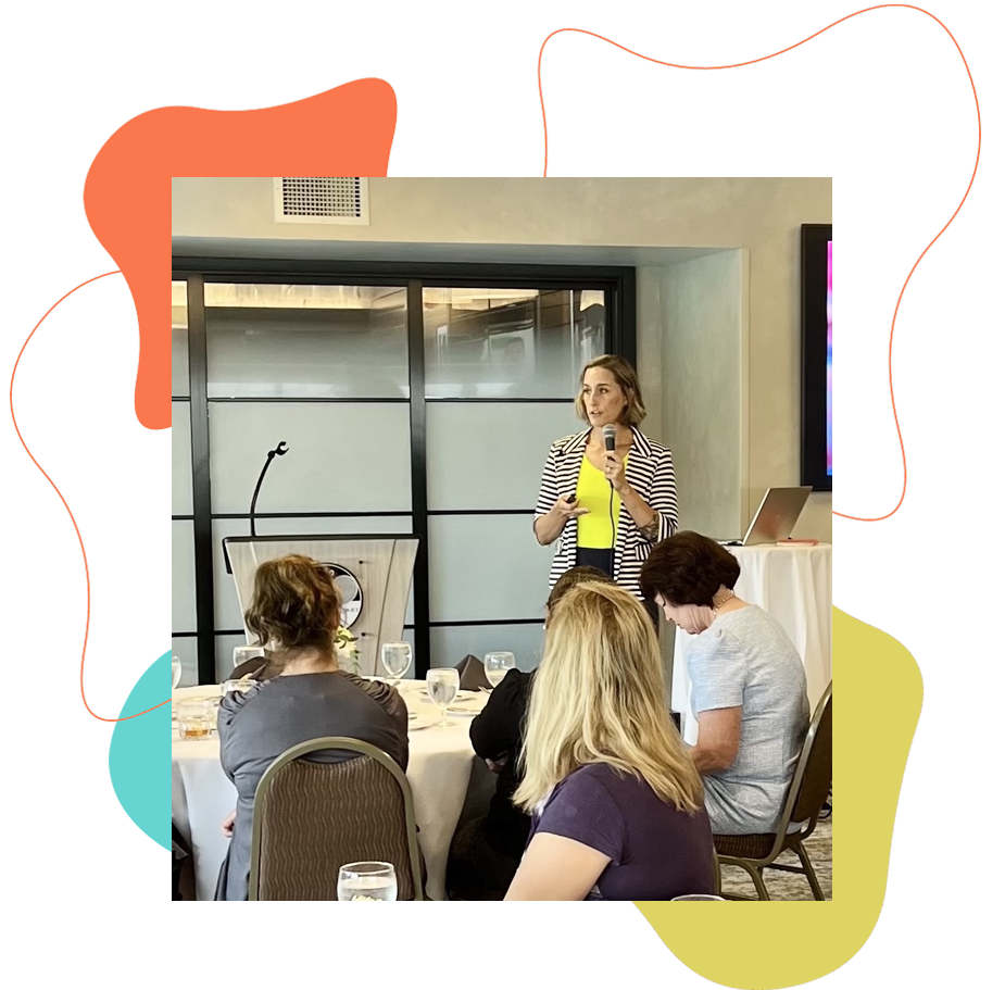 Speaking_Ashley_Schneider Ashley speaking at an event<br />